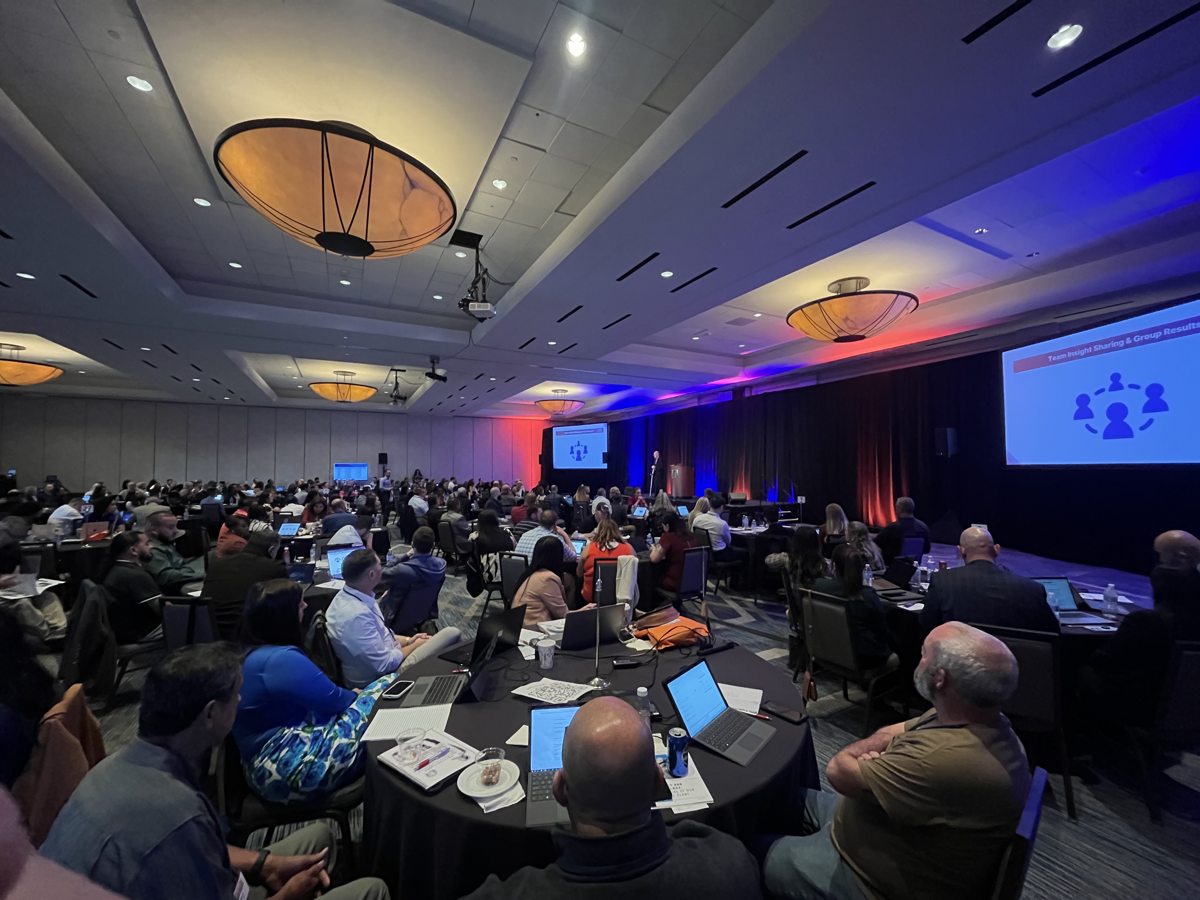 A room of participants listening to a facilitator